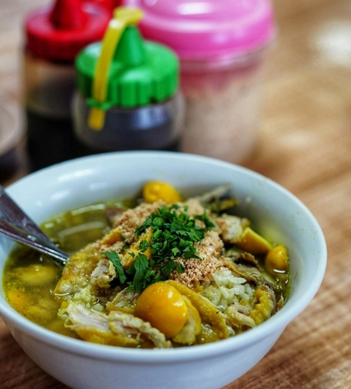 Semangkuk soto ambengan di Jakarta dengan kuah kuning gurih, ayam suwir, dan taburan koya melimpah